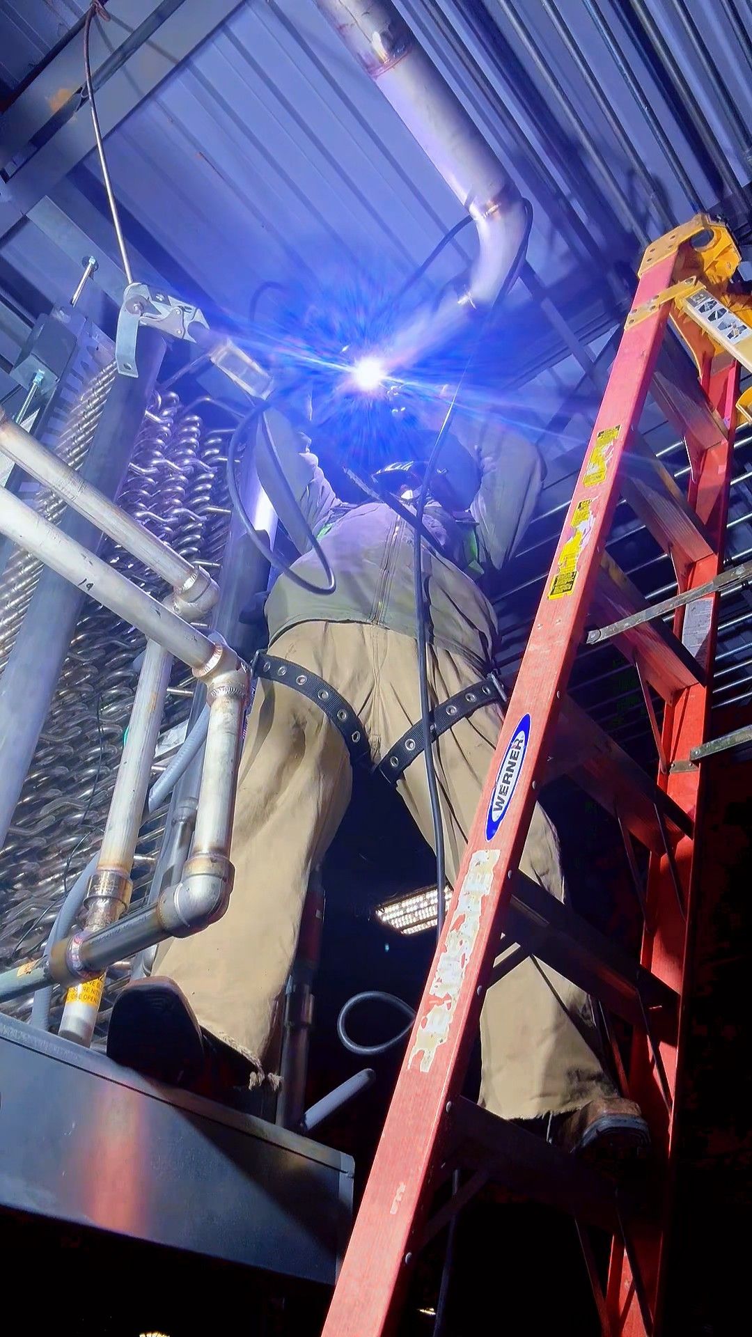 Welder working in a confined space lit by the arc